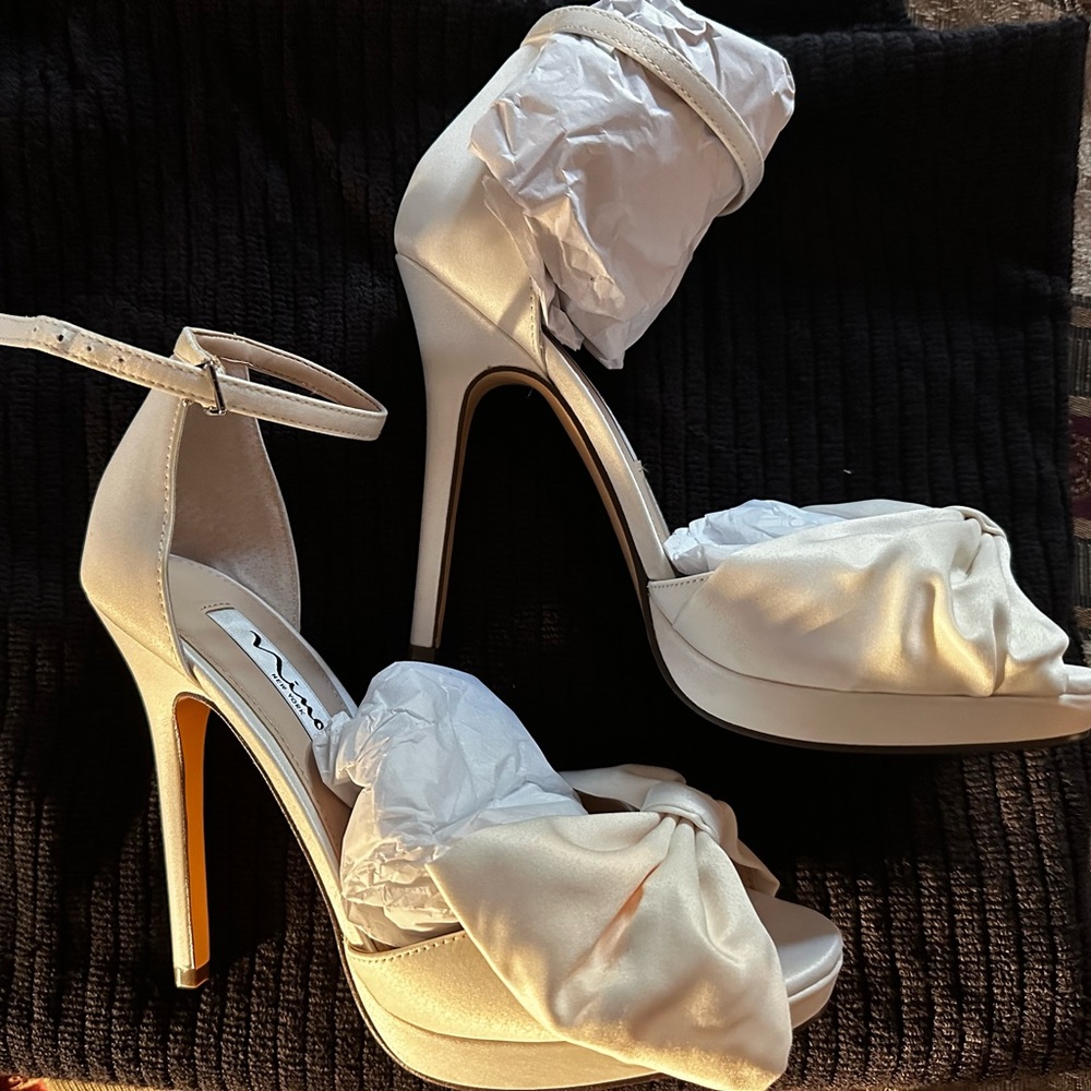 New in Box. 7.5 size
WOMENS IVORY SATIN PLATFORM BOW PEEP-TOE STILETTO SANDAL